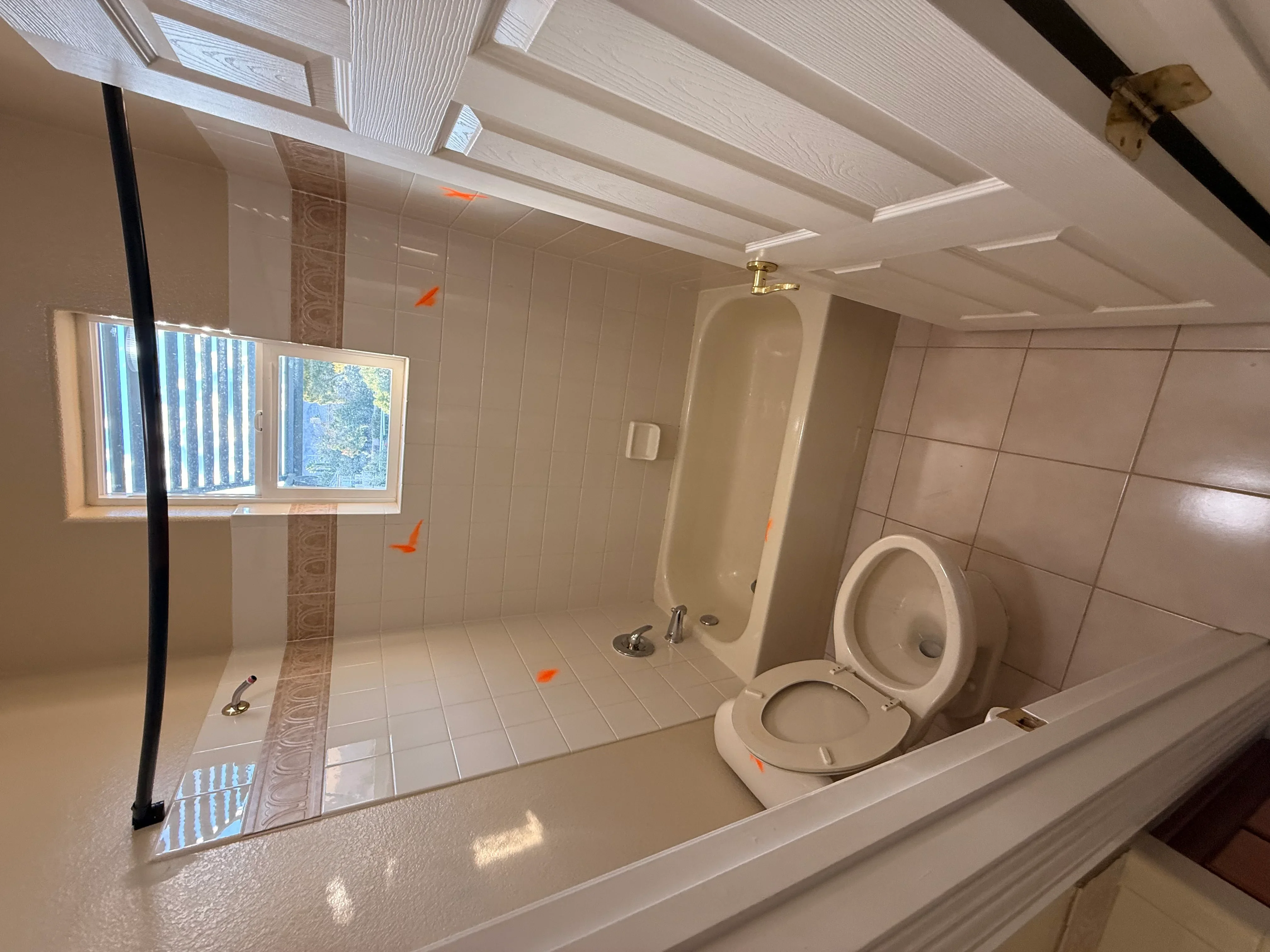 Newly renovated bathroom with ceramic tile flooring, tiled walls, recessed ceiling lights, and updated fixtures