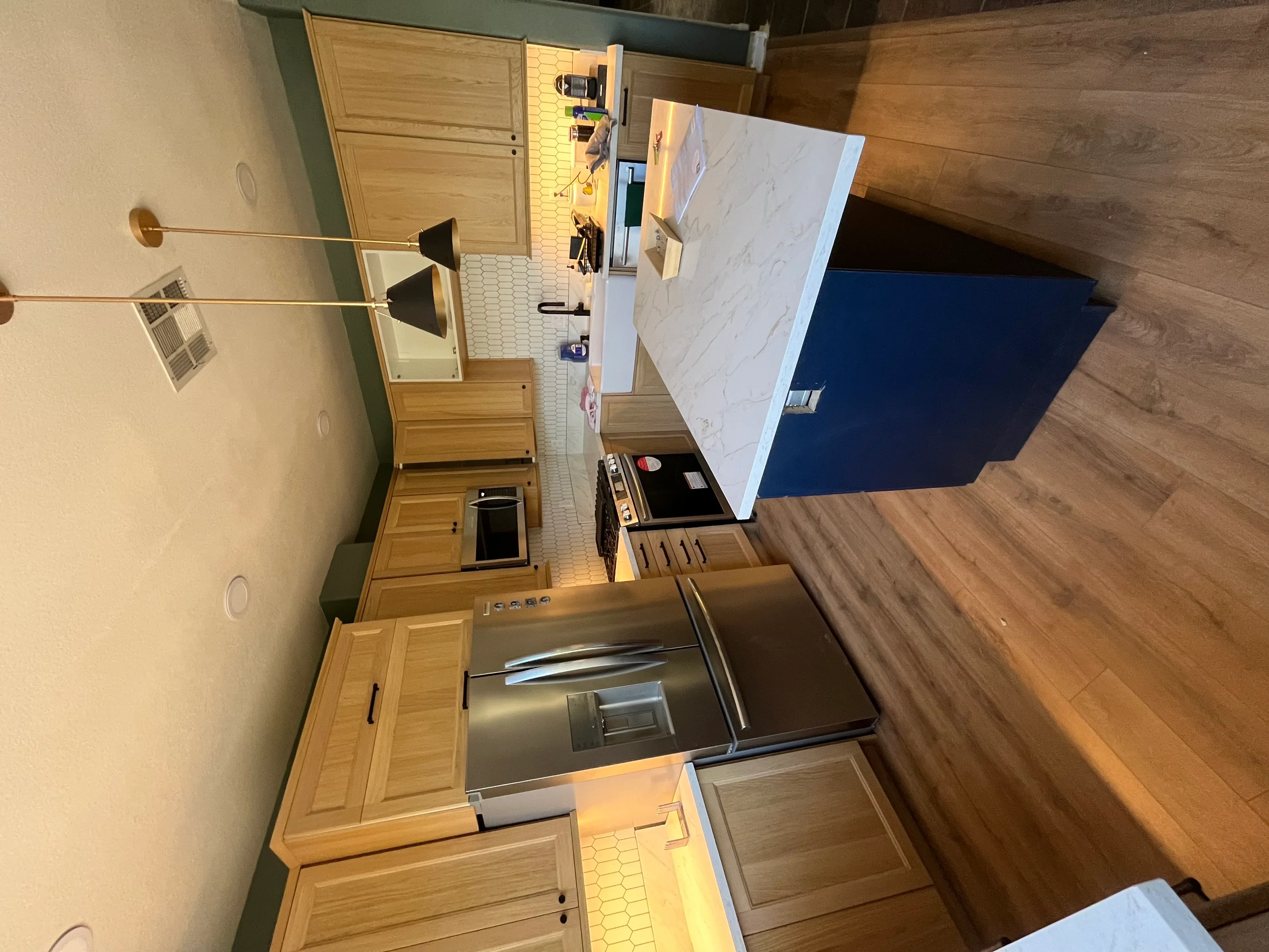 Kitchen with oak cabinets, marble countertops, stainless steel appliances, and new flooring