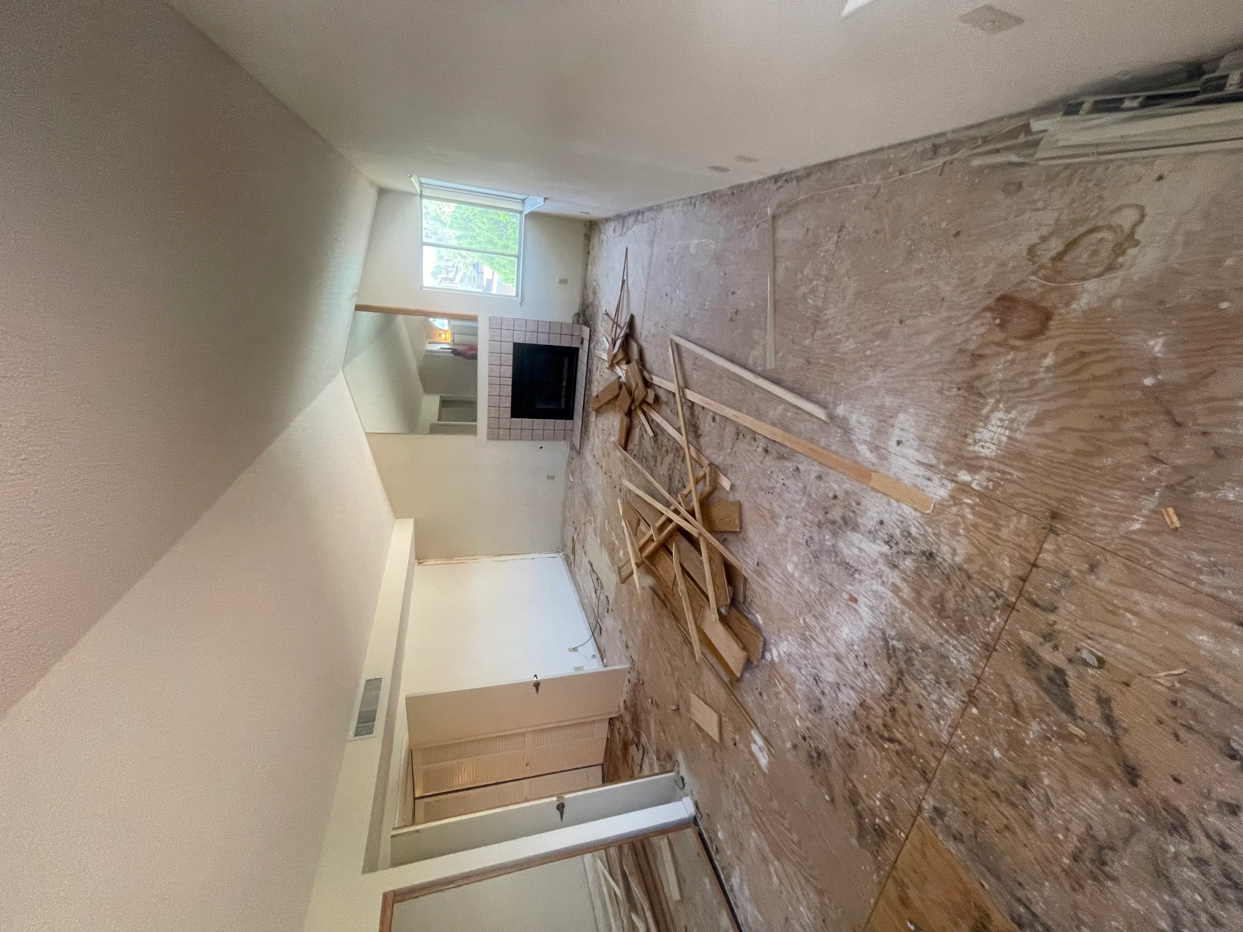 Bathroom remodel with drywall, exposed framing, tile work, and window opening during renovation