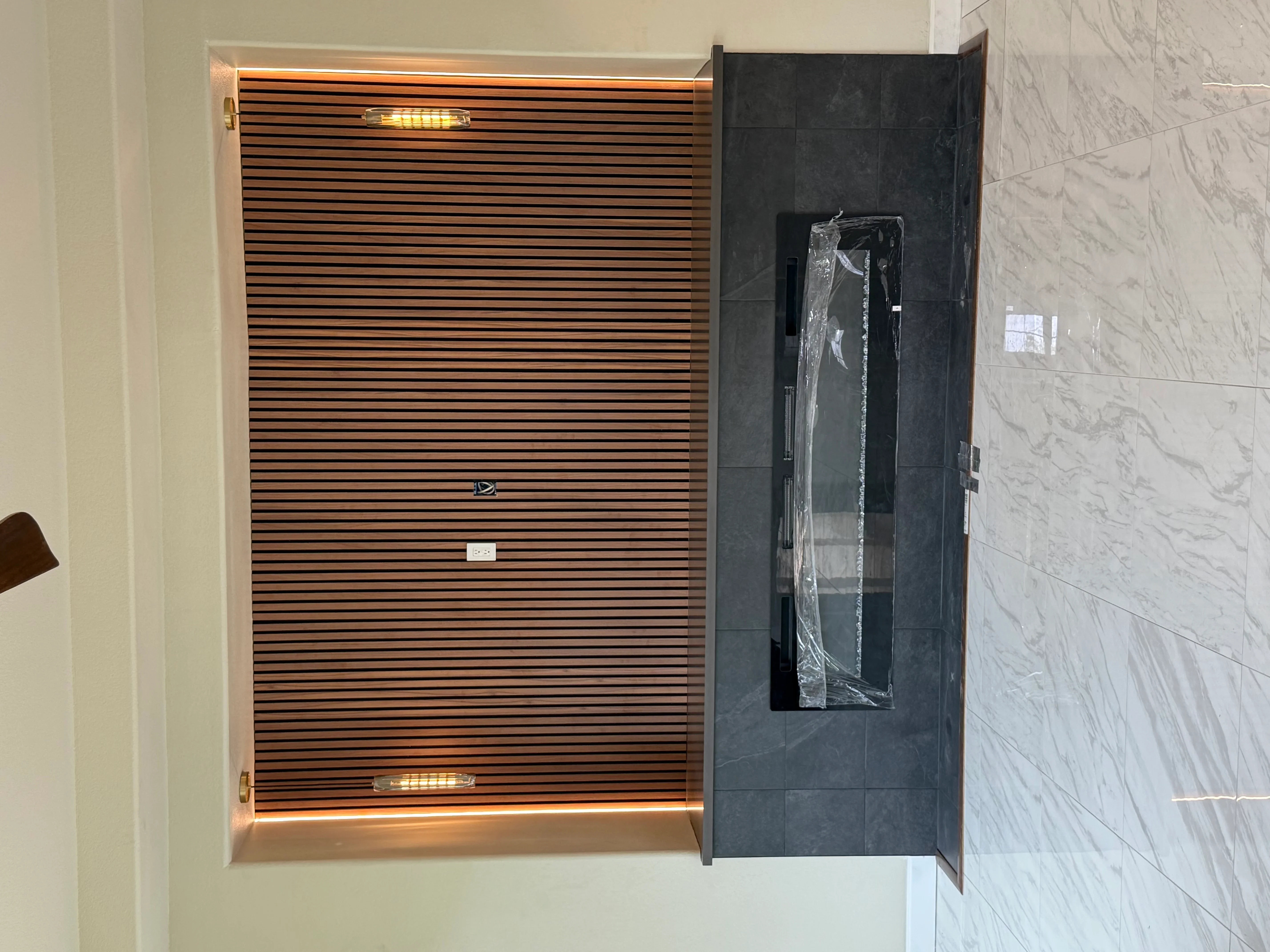 Steam shower with horizontal wood slat paneling, LED lighting, and marble tile surround