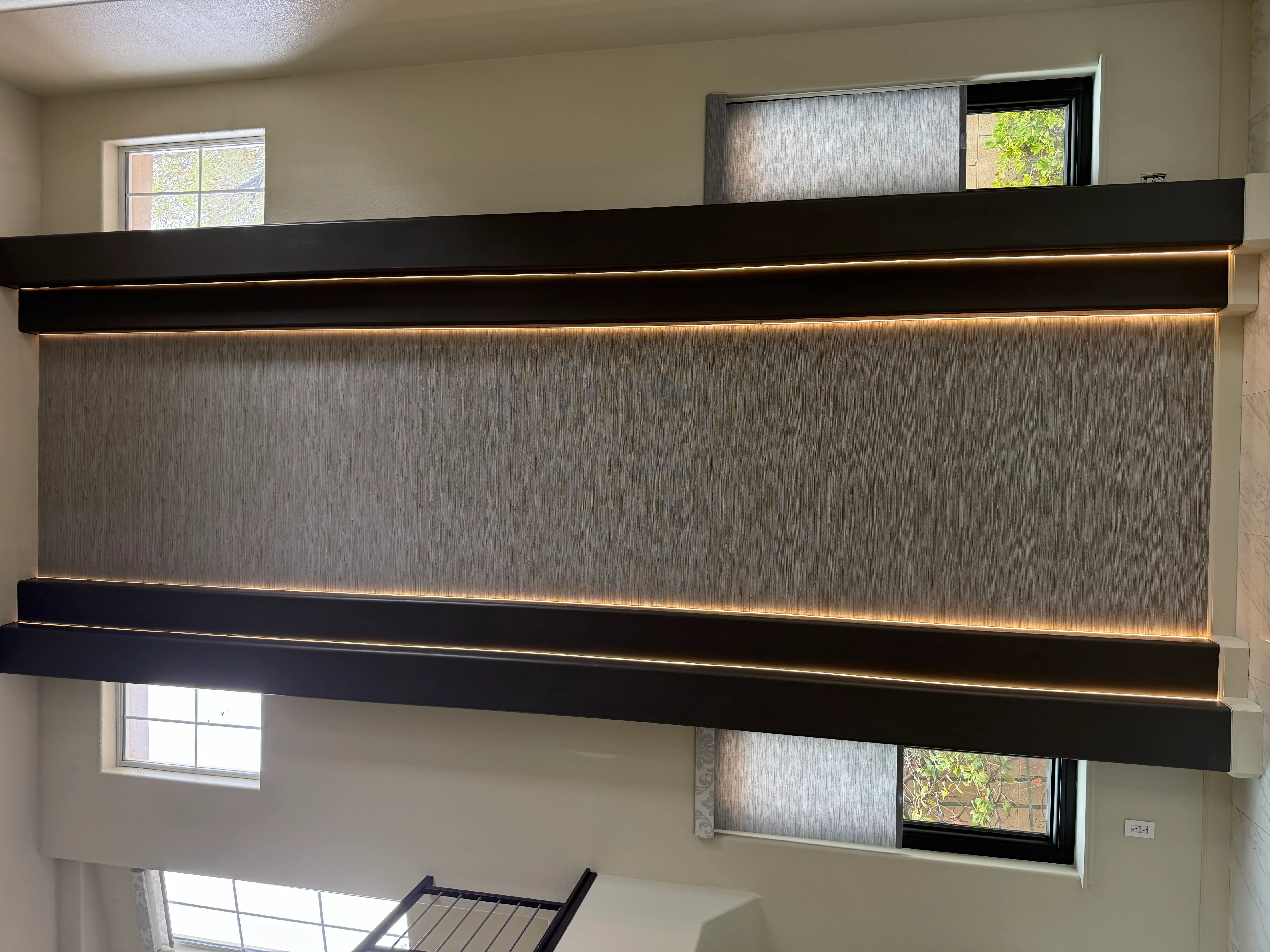 Gray textured accent wall with black trim and warm LED lighting strips