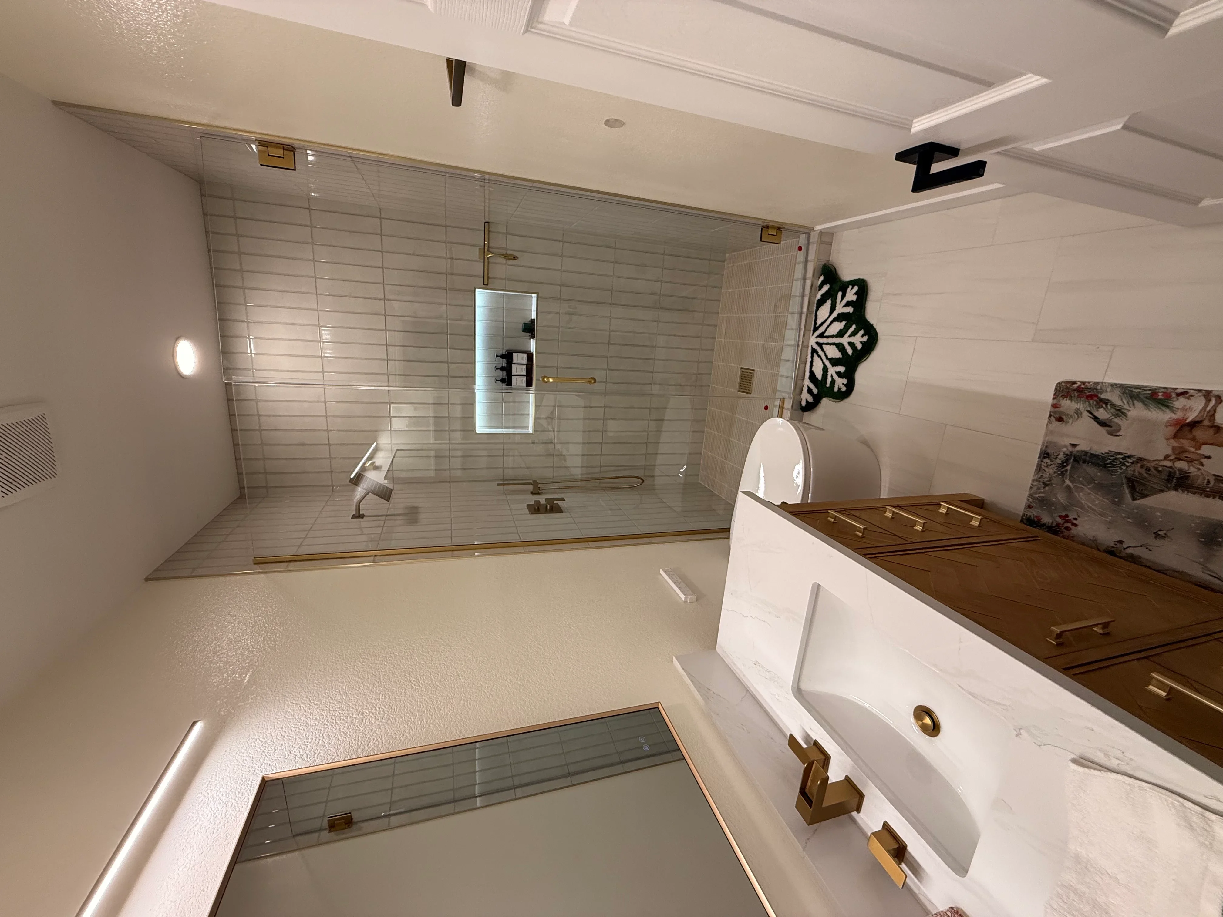 Bathroom with frameless glass shower, subway tile, white vanity, and coffered ceiling
